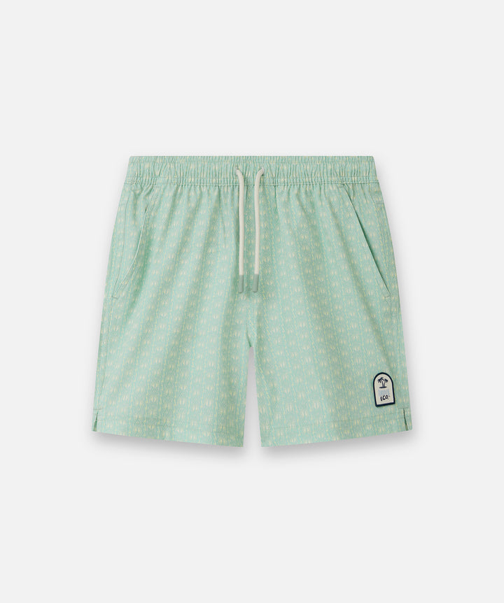 Light green patterned swim shorts with a white drawstring and a small white logo patch on the lower left leg, shown against a light gray background.
